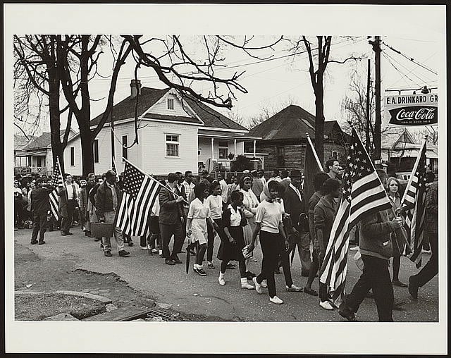 Participants, some carrying American flags, marching in the civil rights march from Selma to Montgomery, Alabama in 1965. Photo courtesy of the Library of Congress
