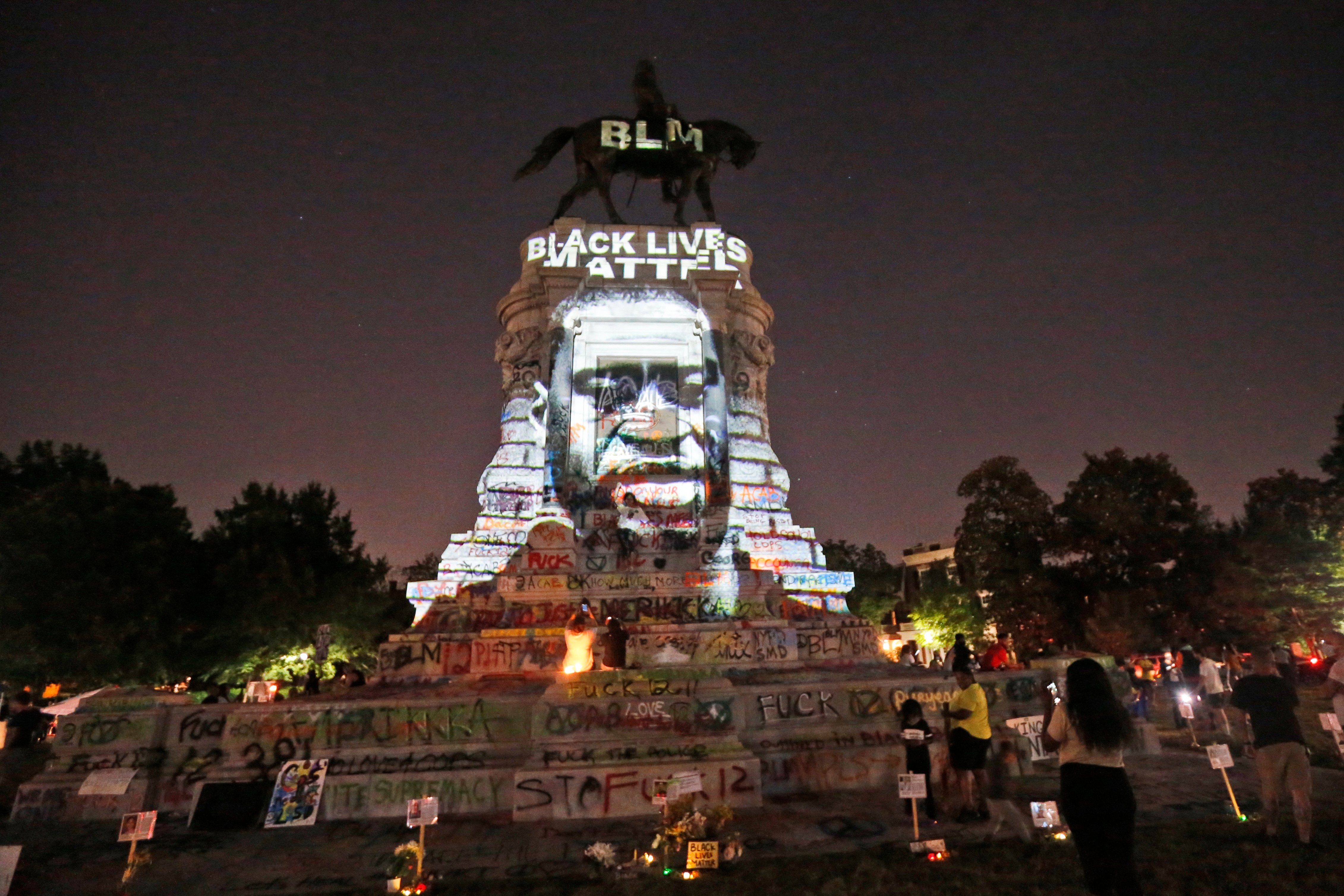 An image of George Floyd is projected on the base of the statue of Confederate General Robert E. Lee on Monument Avenue in Richmond, VA