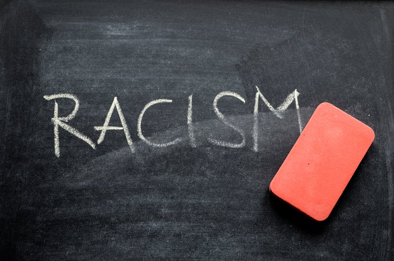 Chalkboard displaying the word "RACISM"