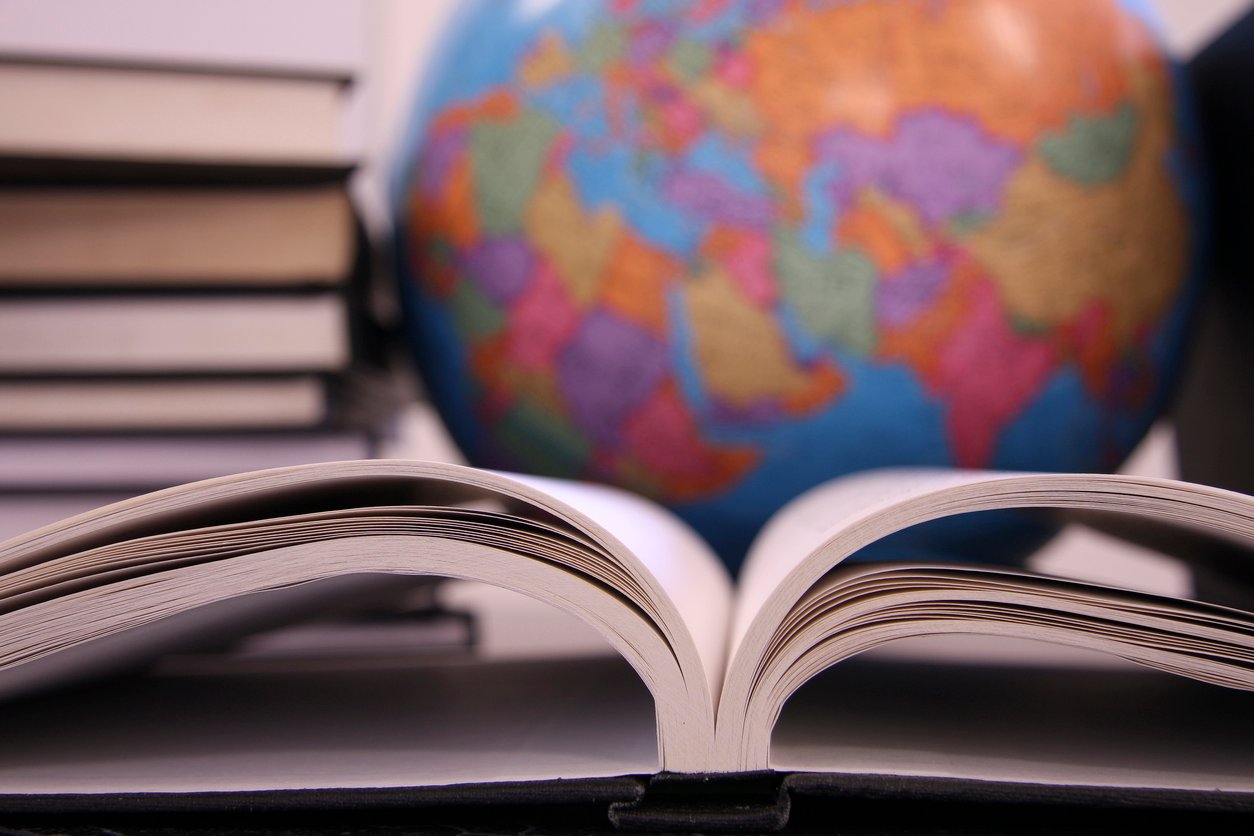 A stack of books, an open book, and a globe